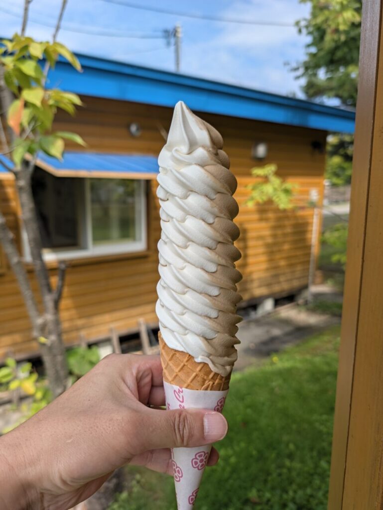 背の高いソフトクリーム。後ろに木造の建物が見える