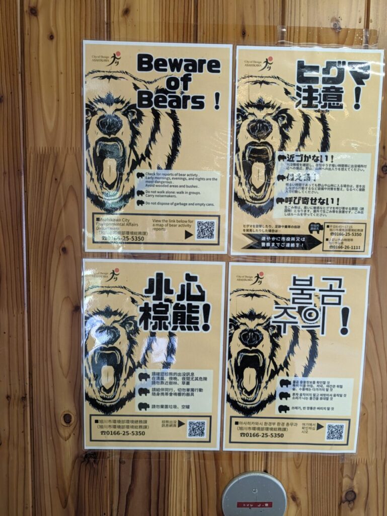 4か国語で書かれたヒグマ注意のポスターが4枚並んで貼られている