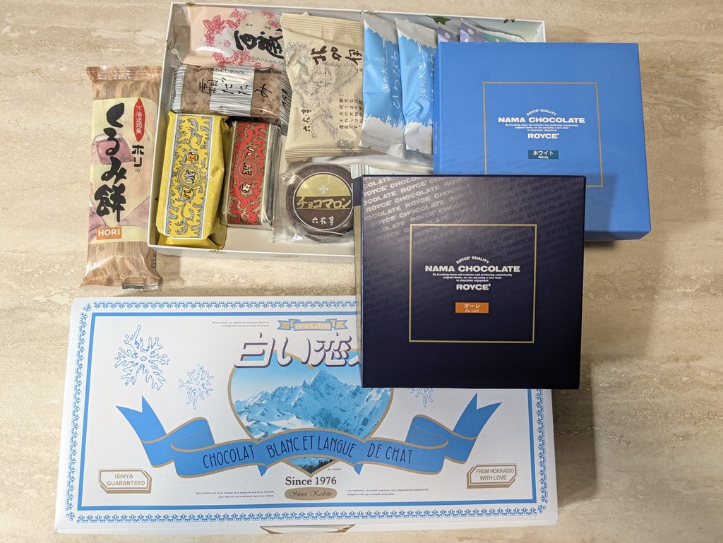 新千歳空港で買ったお土産。白い恋人、ロイズのチョコレート、菓子類が並んでいる